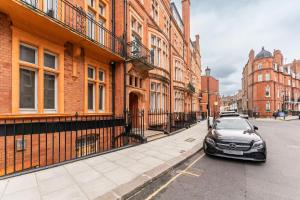 a car parked on a street next to buildings at Elegant 2 Bed Flat in Knightsbridge in London