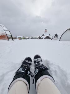 a person standing in the snow with their shoes on at Hunnia - Huntanya in Vlăhiţa