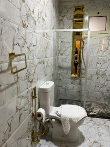 a white bathroom with a toilet and marble walls at Pyramids Top Inn in Cairo +37 photos