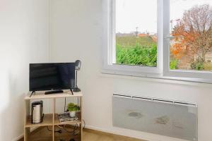 a room with a flat screen tv and a window at Studio cosy bressan in Bourg-en-Bresse