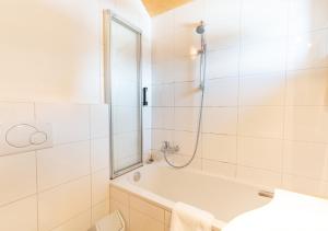 y baño con bañera y ducha. en 1A Chalet Nest - Grillen und Wandern, Panorama Sauna!, en Klippitztorl