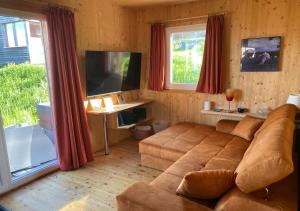 sala de estar con sofá grande y TV en 1A Chalet Nest - Grillen und Wandern, Panorama Sauna! en Klippitztorl