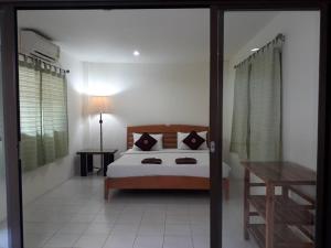 a bedroom with a bed and a table and a window at Penzy Guest House in Chaweng