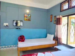 Habitación con cama y TV en la pared. en Kareng guest house, en Kāziranga