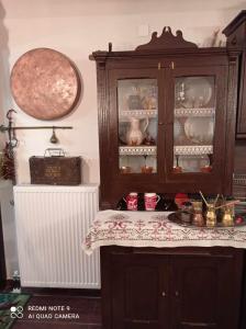 una cocina con un armario de porcelana con una mesa en ΟΡΕΙΝΟ ΟΝΕΙΡΟ en Anilio Metsovo