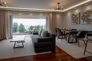 ein Wohnzimmer mit einem Sofa und einem Tisch in der Unterkunft Sesilia Sea View Apartment in Athen