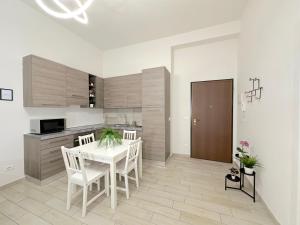 cocina con mesa blanca y sillas en una habitación en Casa Camilla, en Bolonia
