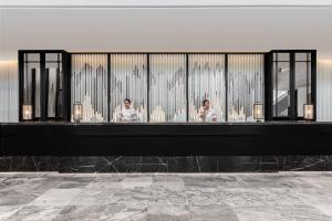 two people standing in front of a bathroom at Courtyard by Marriott Phuket Town in Phuket Town