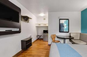 Motel 6-Napa, CA في نابا: غرفة بسرير وطاولة مع تلفزيون
