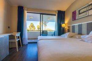 Habitación de hotel con 2 camas y balcón en Hotel La Palma de Llanes, en Llanes
