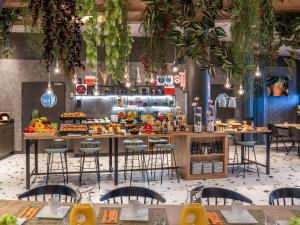 a restaurant with a buffet with tables and chairs at Ibis Madrid Aeropuerto Barajas in Madrid