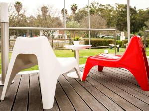 2 sillas y una mesa en una terraza en Hotel ibis Lisboa Alfragide, en Lisboa