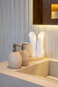 a bathroom counter with towels and toiletries on it at Pura Eco Retreat, Jebel Hafit Desert Park in Al Ain