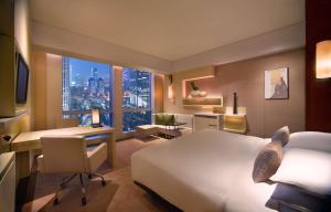 a hotel room with a bed and a desk and a desk at Grand Hyatt Guangzhou-Free Shuttle Bus to Canton Fair Complex During Canton Fair Period in Guangzhou