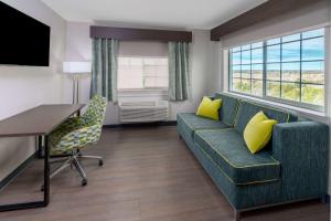a living room with a couch and a table and yellow pillows at La Quinta by Wyndham Santa Rosa in Santa Rosa