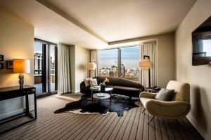 a living room with a couch and chairs and a large window at Thompson Chicago, by Hyatt in Chicago