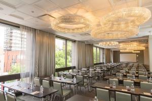 une salle de conférence avec des tables, des chaises et des lustres dans l'établissement Thompson Chicago, by Hyatt, à Chicago