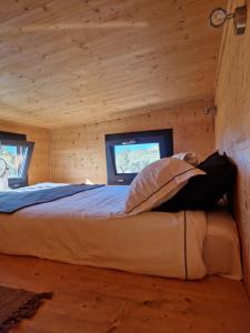 a bedroom with a bed in a log cabin at Location Tiny House Loule in Loulé