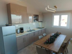 eine Küche mit einem Holztisch und einem Kühlschrank in der Unterkunft Amazing view with huge balcony in Veria