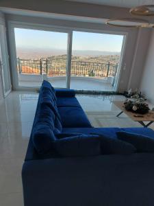 a blue couch in a living room with a large window at Amazing view with huge balcony in Veria