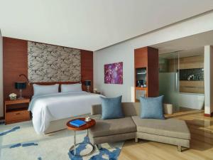 a hotel room with a bed and a couch at Fairmont Bab Al Bahr in Abu Dhabi