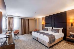 um quarto de hotel com uma cama grande e uma secretária em TRYP By Wyndham Istanbul Sisli Hotel em Istambul