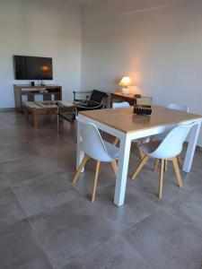 a table and chairs in a living room with a television at Departamento Margaritas in Santa Rosa +10 photos