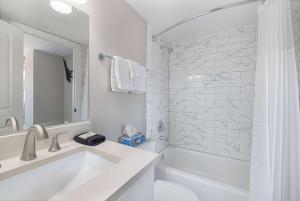 y baño blanco con lavabo y bañera. en Georgetown Residences by LuxUrban en Washington