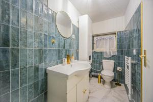 een badkamer met een wastafel, een toilet en een spiegel bij Le 2en1 Roissy CDG in Longperrier
