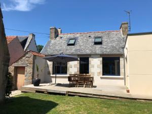 a patio with a table and an umbrella at Ker Moumousse in Trébeurden