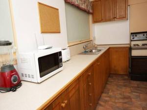 a kitchen counter with a microwave and a sink at It's on Walnut in Mildura