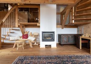 a living room with a fireplace and stairs at 1A Chalet '4 Jahreszeiten' Wandern, Grillen und Jacuzzi mit Aussicht! in Bad Sankt Leonhard im Lavanttal