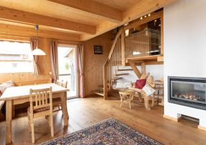 a living room with a table and a fireplace at 1A Chalet '4 Jahreszeiten' Wandern, Grillen und Jacuzzi mit Aussicht! in Bad Sankt Leonhard im Lavanttal