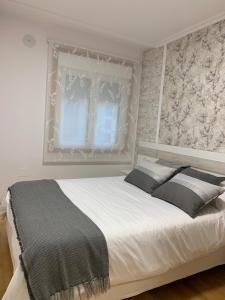 Un dormitorio con una gran cama blanca y una ventana. en MANSIÓN DEL INDIANO, en Viveiro