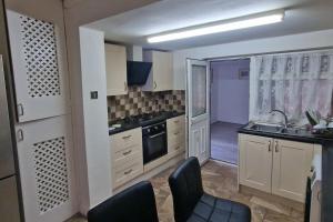eine Küche mit weißen Schränken und schwarzen Stühlen in der Unterkunft 3 Bedrooms semi-detached house,near airport,NEC in Birmingham