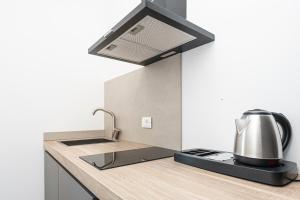 a kitchen with a sink with a tea kettle at Le Finestre Boutique Apartments in Trieste