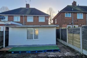 ein Haus mit einer Garage vor einem Zaun in der Unterkunft 3 Bedrooms semi-detached house,near airport,NEC in Birmingham