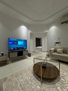 een woonkamer met een grote flatscreen-tv bij Family Modern 2BDR Apartment in Riyad