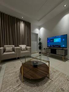 een woonkamer met een grote flatscreen-tv bij Family Modern 2BDR Apartment in Riyad