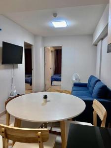 uma sala de estar com uma mesa branca e um sofá azul em 2Bedroom, WiFi, washing machine and small kitchen em Pak Kret