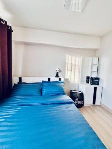 um quarto com uma cama com um cobertor azul em 2Bedroom, WiFi, washing machine and small kitchen em Pak Kret