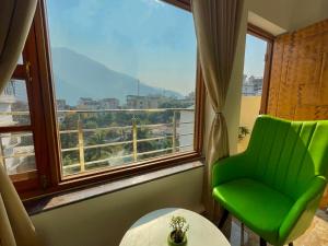 a green chair in a room with a large window at Wanna Stay Rishikesh in Rishīkesh