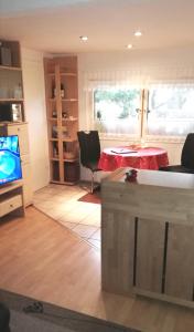 a living room with a table and a television at Waldesruh Strausberg in Strausberg