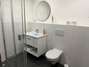 a white bathroom with a toilet and a mirror at Gemütliche Wohnung mit Terrasse in Blumberg