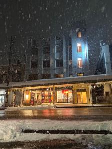 a building on a city street in the snow at 駅本ビル民宿 in Yuzawa