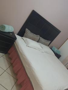 a bed with a black headboard and a night stand at Jean Michael Self-catering apartment for stay overs in Pretoria