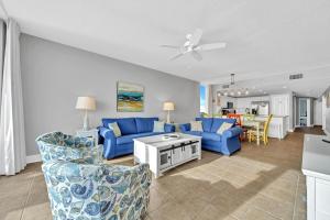 una sala de estar con sofás azules y una mesa. en Majestic Beach Towers 2-1701 en Panama City Beach