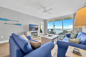 a living room with blue couches and a tv at Majestic Beach Towers 2-1701 in Panama City Beach