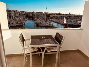 einen Tisch und Stühle auf einem Balkon mit Hafen in der Unterkunft Studio apt with spectacular views of Lagos Marina in Lagos