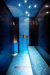 uma casa de banho azul com um chuveiro com azulejos azuis em Erzsebet19 Apartment em Budapeste